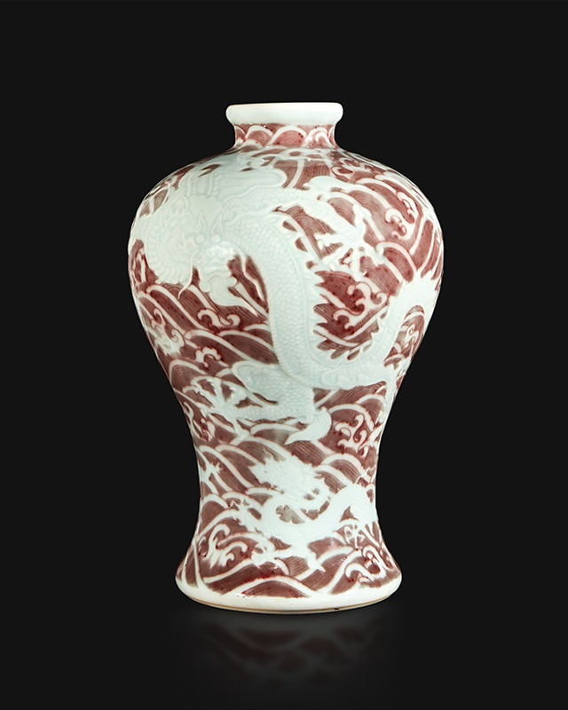 A Chinese Underglaze Red and Blue-Decorated Carved Porcelain ‘Dragons and Waves’ Meiping Vase