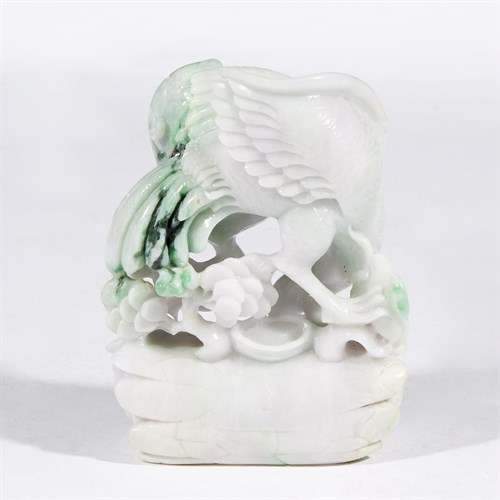 Lot 284 - A carved white and green jadeite model of an eagle on pine log