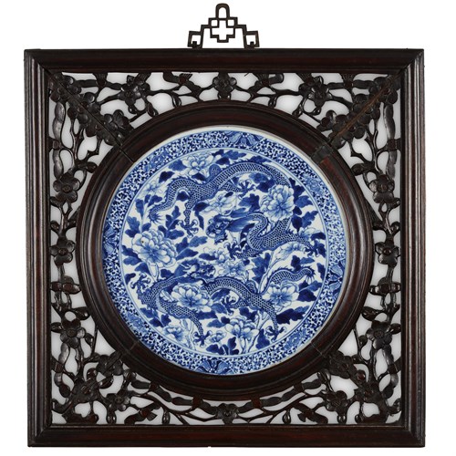Lot 224 - A Chinese blue and white porcelain "Double Dragon" plaque in carved and pierced wood frame
