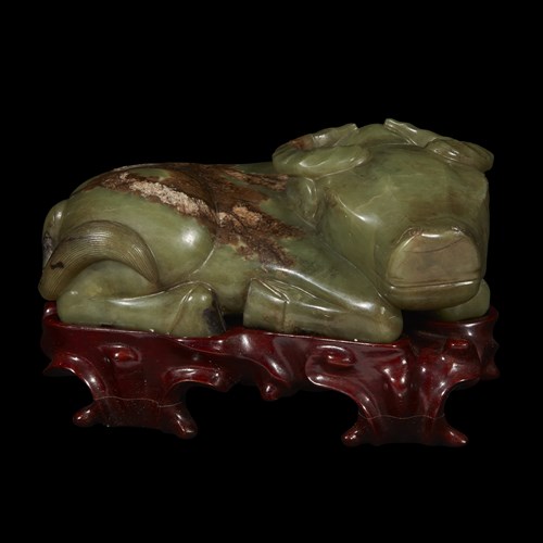 Lot 251 - A Chinese celadon and brown jade carving of a recumbant water buffalo