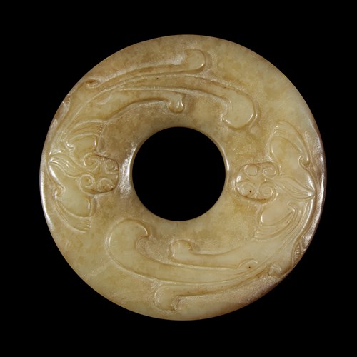 Lot 249 - A Chinese archaistic carved celadon and russet jade small bi-disk