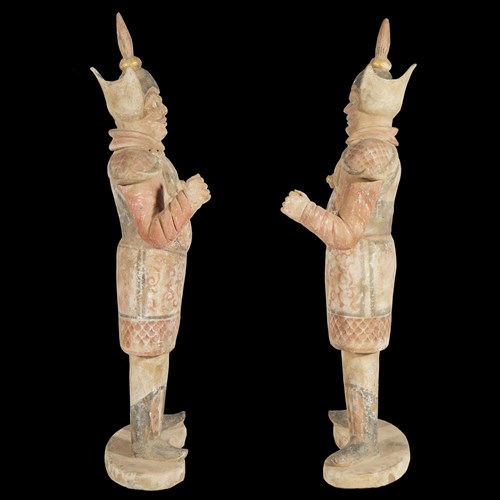 Lot 24 - A pair of Chinese painted and parcel gilt pottery figures of warriors