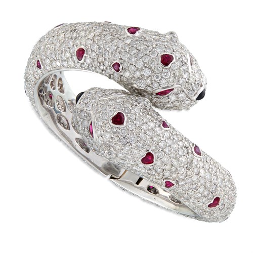 Lot 111 - A diamond, ruby, emerald, and eighteen karat white gold bangle