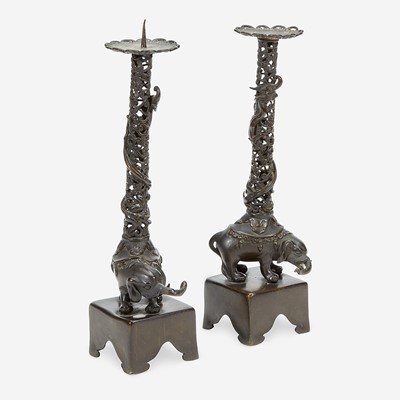 Lot 129 - A pair of Japanese "Elephant and Dragon" patinated bronze openwork pricket candlesticks