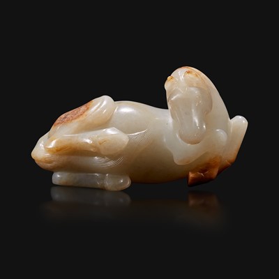 Lot 100 - A Chinese russet and greyish-white carved jade figure of a recumbent horse