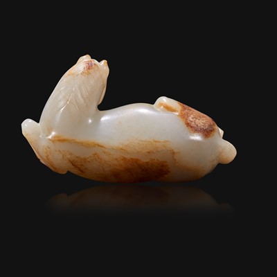 Lot 100 - A Chinese russet and greyish-white carved jade figure of a recumbent horse