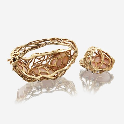 Lot 68 - An angel skin coral, diamond, and fourteen karat gold bangle with matching ring
