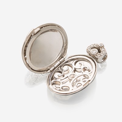 Lot 135 - An eighteen karat white gold and diamond pendant locket