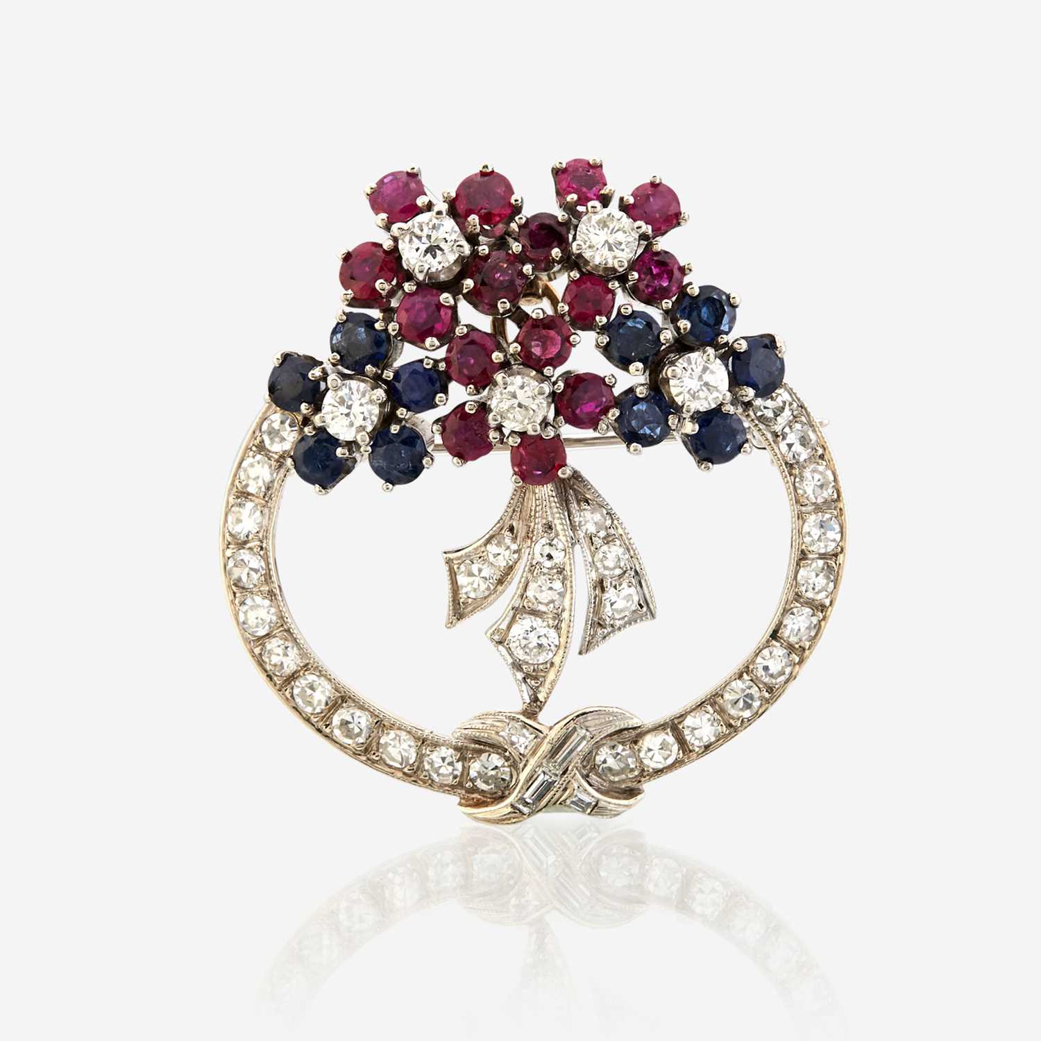 Lot 40 - A diamond, ruby, sapphire, and white gold pendant/brooch