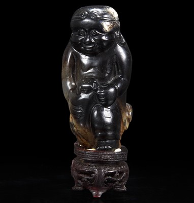 Lot 80 - An unusual Chinese dark brown-black jade carving of a Lohan 笑狮罗汉玉雕