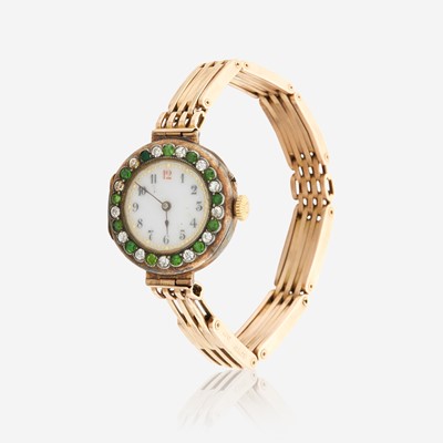 Lot 128 - A gold, diamond, and green stone bracelet watch, Swiss