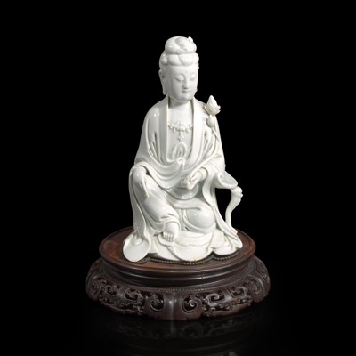 Lot 89 - A Chinese blanc de Chine figure of Guanyin seated, with lotus 白瓷持莲观音像