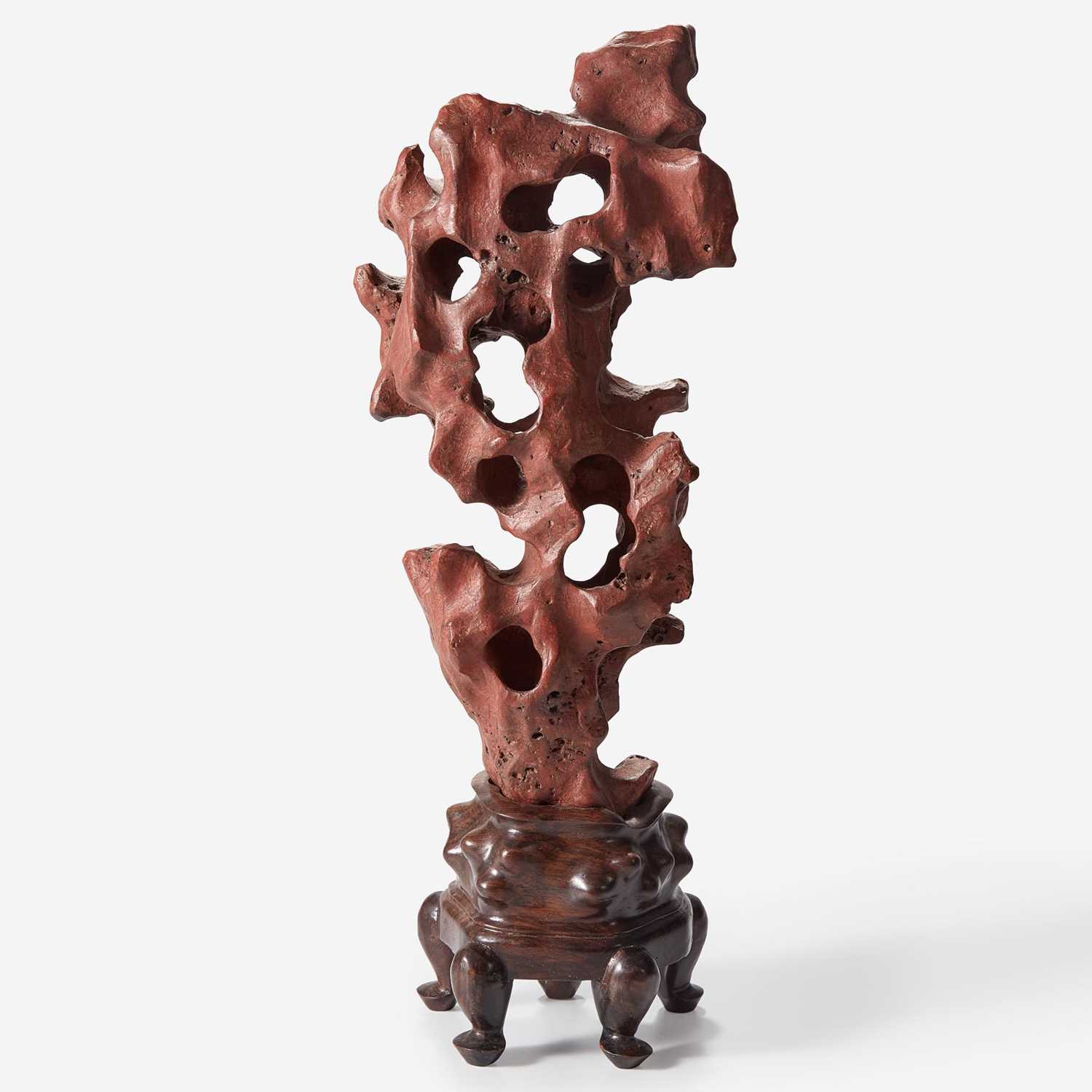 Lot 102 - A Chinese scholar's rock on wood stand, possibly red Taihu stone