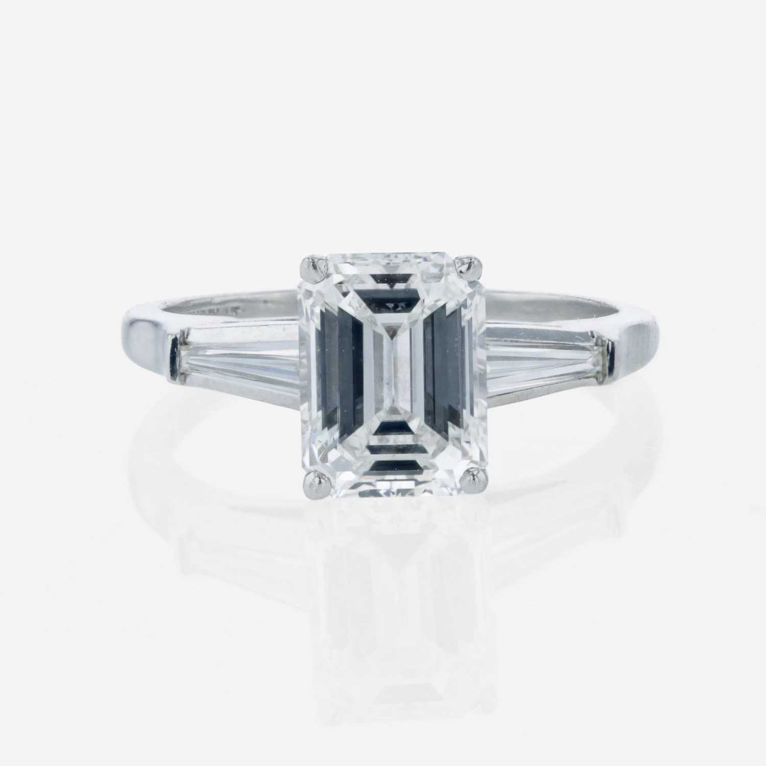 Lot 86 - An emerald-cut diamond accented solitaire ring