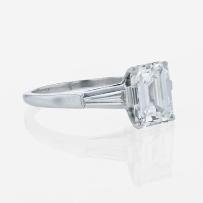 Lot 86 - An emerald-cut diamond accented solitaire ring