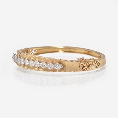 Lot 259 - A 14K Gold and Diamond Bangle Bracelet