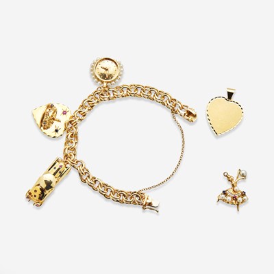 Lot 101 - A 14K Yellow Gold Charm Bracelet with 14K Yellow Gold and Gemstone Charms
