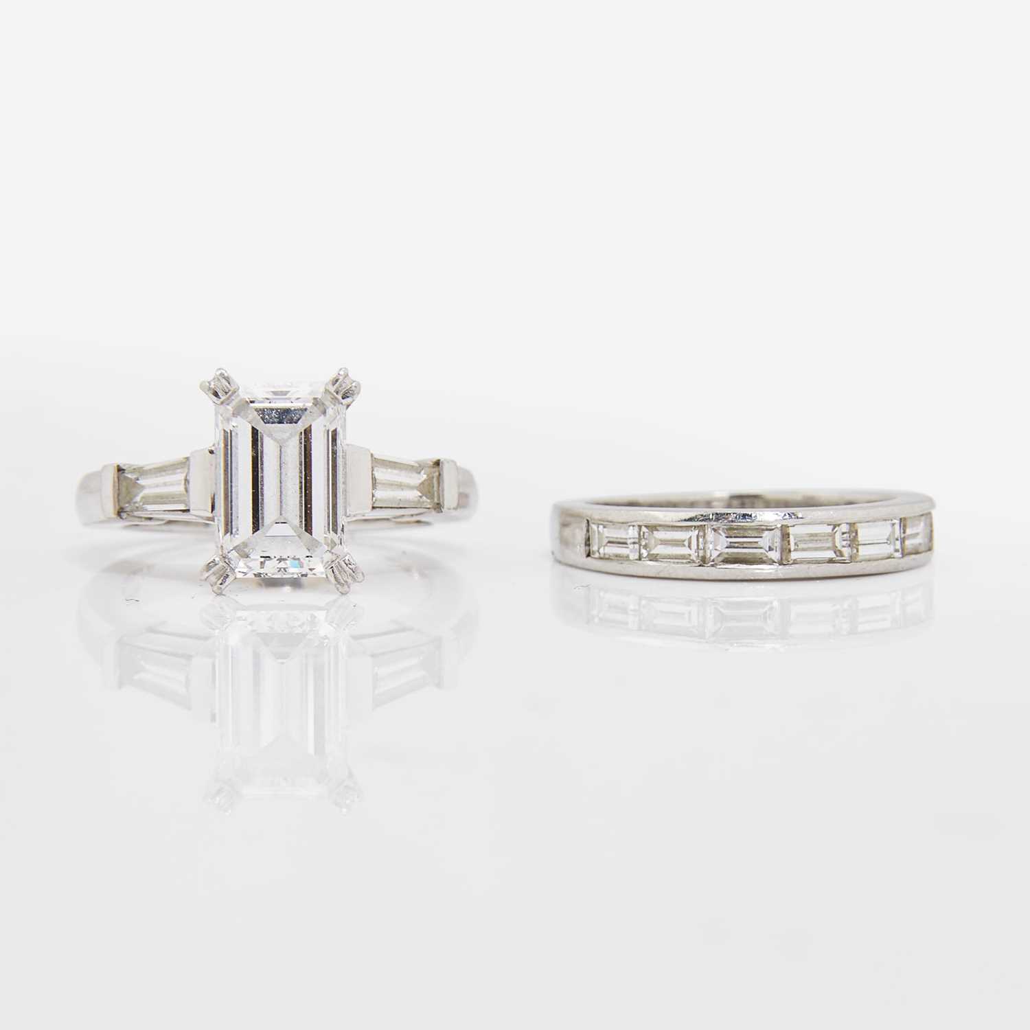 Lot 58 - An Emerald-Cut Diamond and Platinum Ring and Band