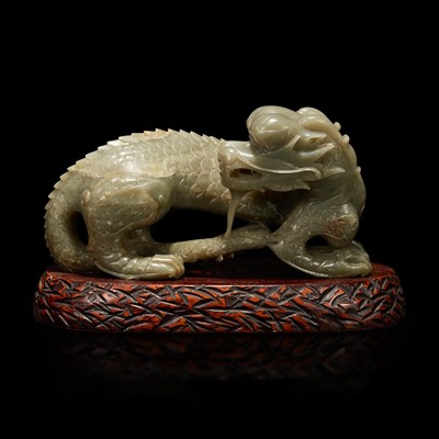 Lot 61 - A Chinese carved celadon-grey jade dragon and wood stand 青灰玉龍及木底座