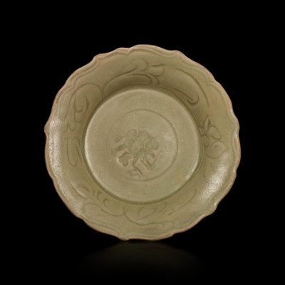 Lot 33 - A Chinese Longquan celadon small molded and incised barbed dish 龍泉青釉模印刻劃蓮瓣盤