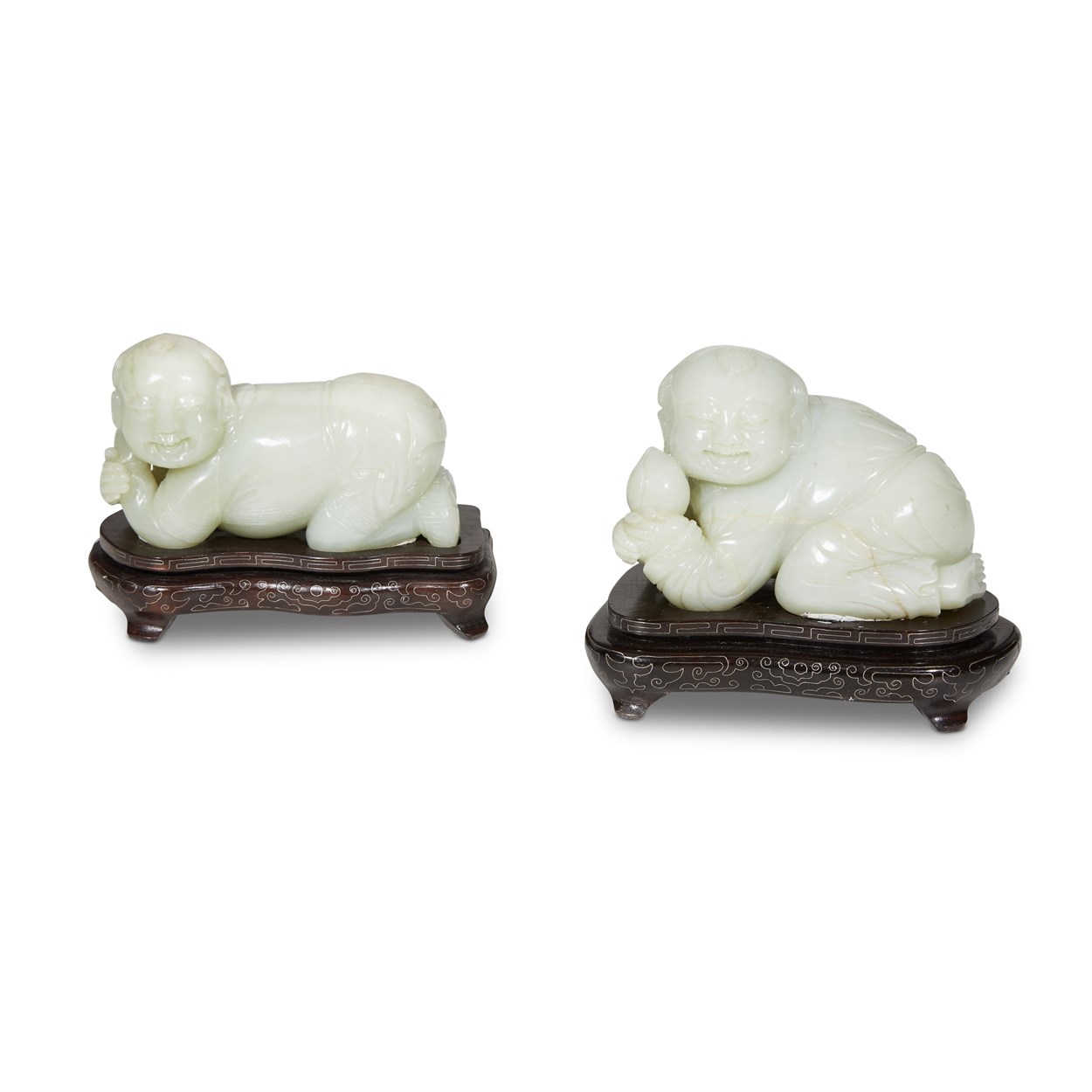 Lot 138 - Two similar pale celadon jade figures of kneeling boys