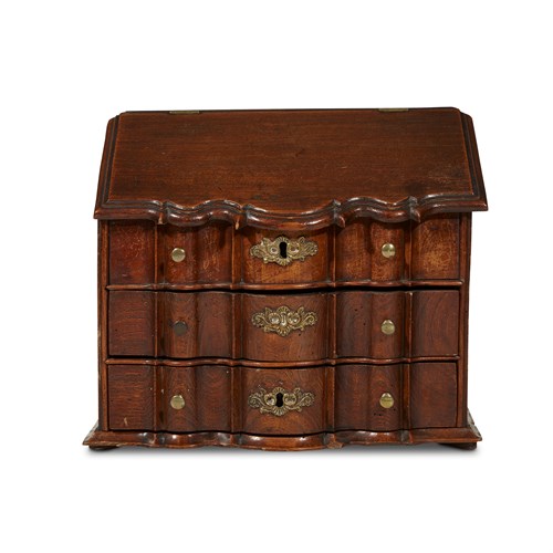 Lot 90 - A George III style miniature walnut serpentine front three-drawer chest