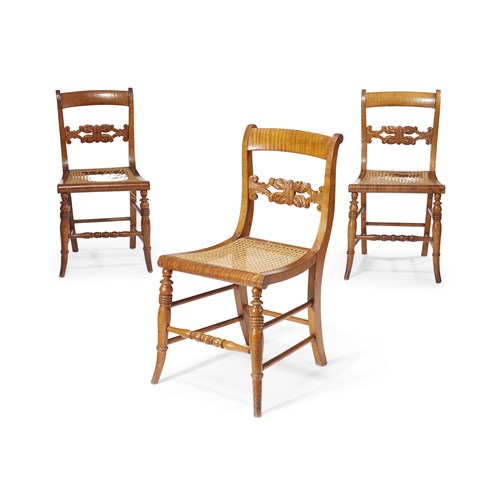 Lot 227 - Three tiger maple "Klismos" side chairs with carved back rests and caned seats