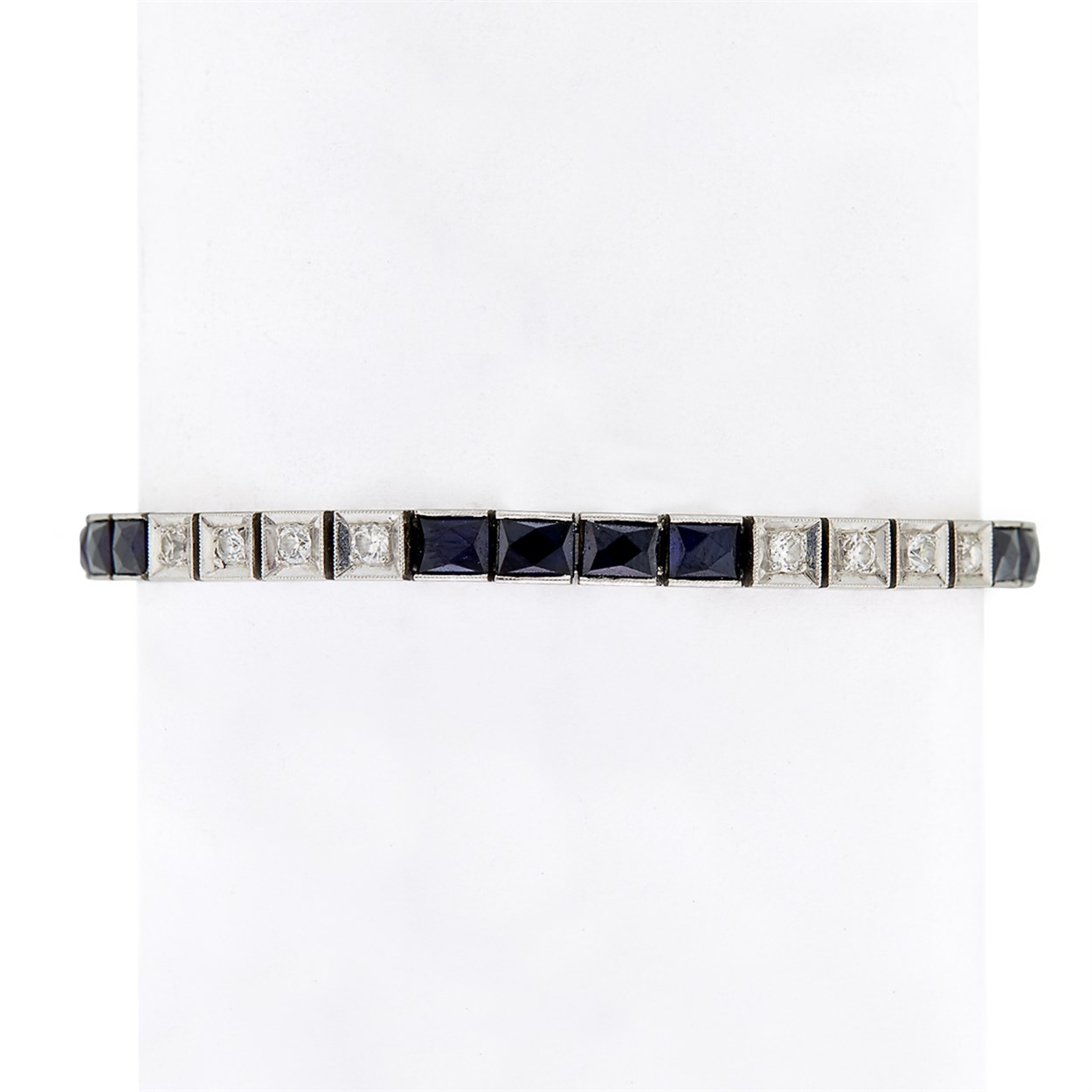 Lot 19 - A diamond, synthetic sapphire and platinum line bracelet
