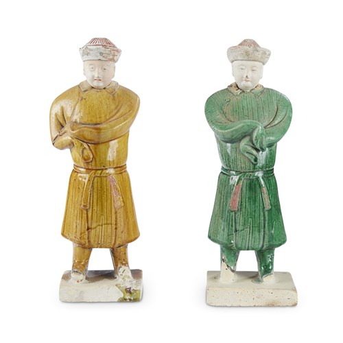 Lot 250 - Two painted and glazed pottery figures of standing attendants