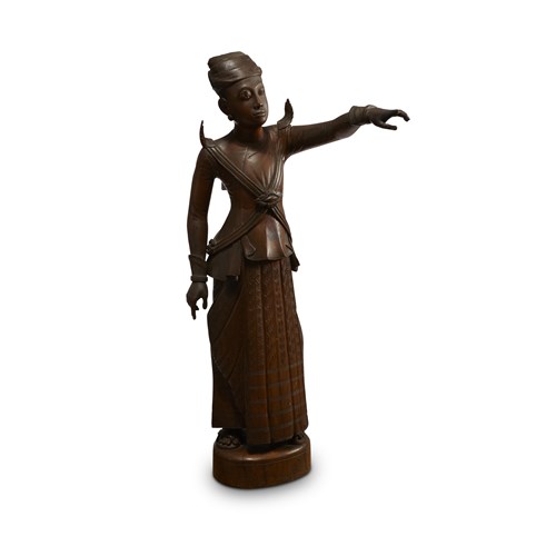 Lot 120 - A Burmese carved wood figure of a standing man, pointing in the distance