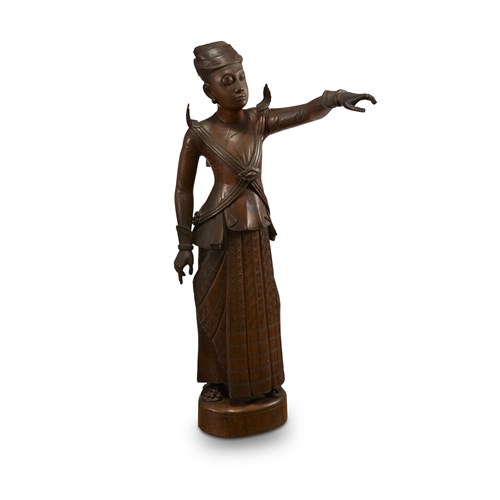 Lot 120 - A Burmese carved wood figure of a standing man, pointing in the distance